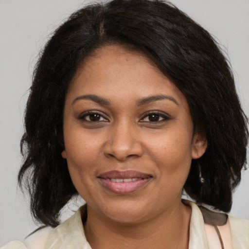 Joyful black young-adult female with medium  brown hair and brown eyes