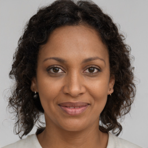 Joyful black young-adult female with medium  brown hair and brown eyes