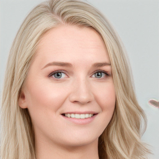 Joyful white young-adult female with long  blond hair and blue eyes