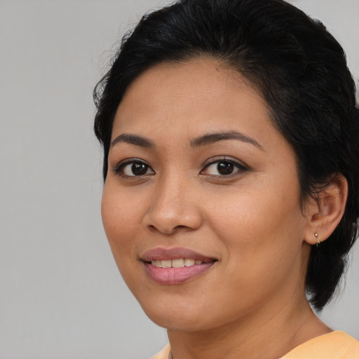 Joyful latino young-adult female with medium  brown hair and brown eyes