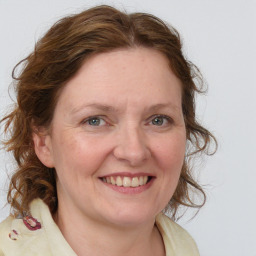 Joyful white adult female with medium  brown hair and blue eyes