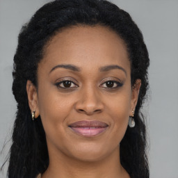 Joyful black adult female with long  brown hair and brown eyes