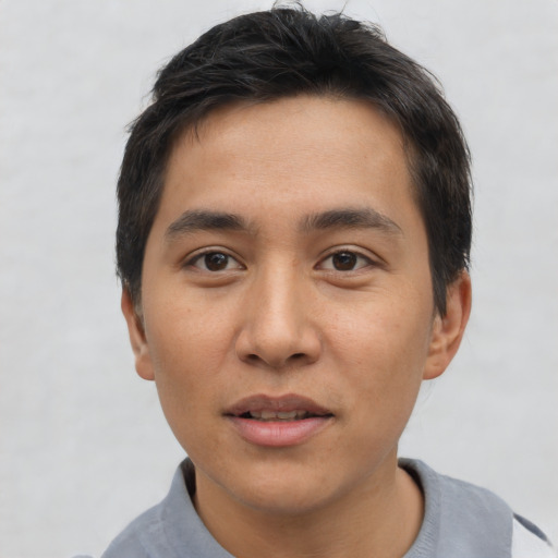 Joyful asian young-adult male with short  black hair and brown eyes