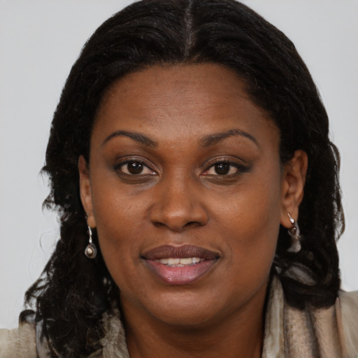 Joyful black young-adult female with long  brown hair and brown eyes