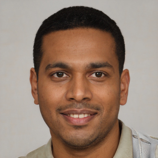 Joyful latino young-adult male with short  black hair and brown eyes