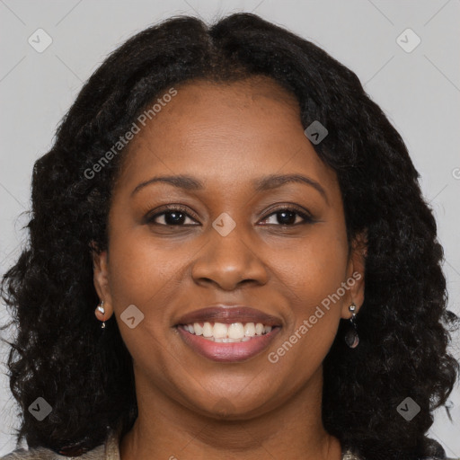 Joyful black young-adult female with long  brown hair and brown eyes