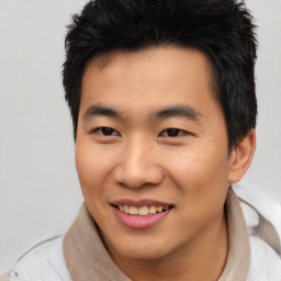 Joyful asian young-adult male with short  brown hair and brown eyes