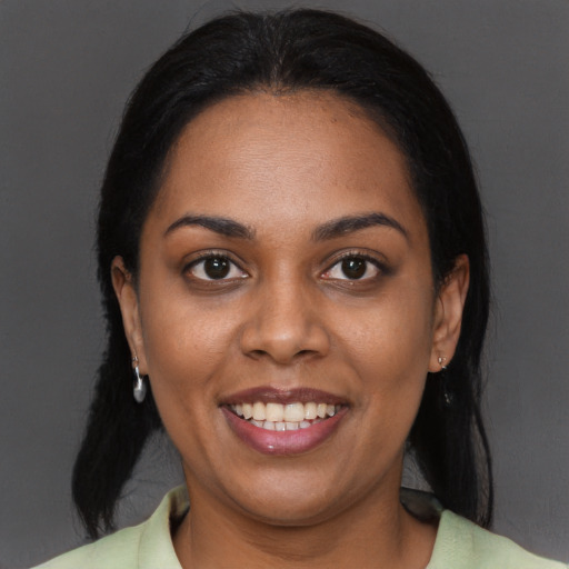 Joyful black young-adult female with long  black hair and brown eyes