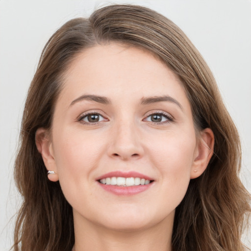 Joyful white young-adult female with long  brown hair and grey eyes