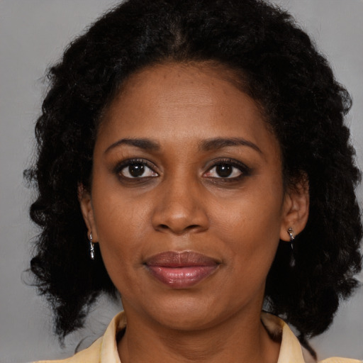 Joyful black adult female with medium  brown hair and brown eyes