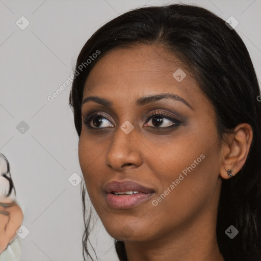 Joyful black young-adult female with long  black hair and brown eyes