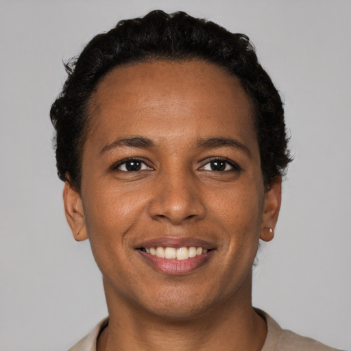 Joyful black young-adult female with short  black hair and brown eyes