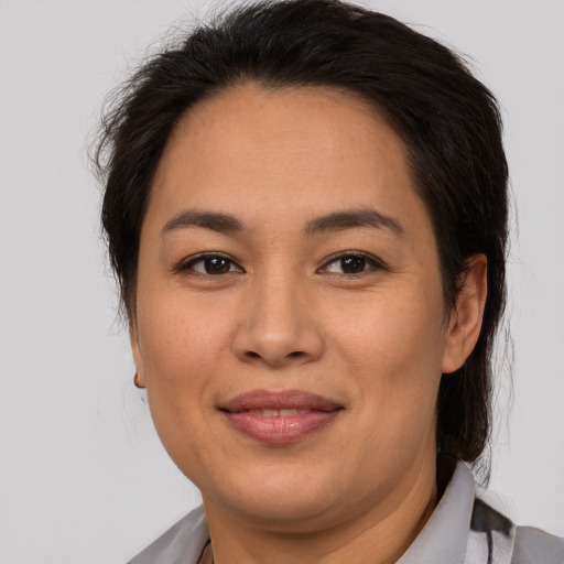 Joyful asian adult female with medium  brown hair and brown eyes