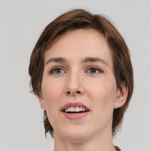 Joyful white young-adult female with medium  brown hair and green eyes