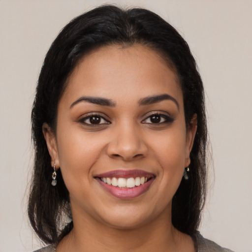 Joyful latino young-adult female with medium  brown hair and brown eyes