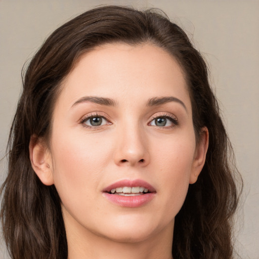 Joyful white young-adult female with long  brown hair and brown eyes