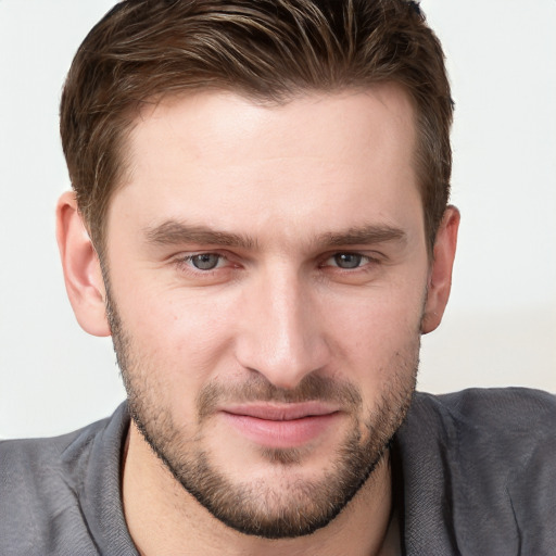 Joyful white young-adult male with short  brown hair and grey eyes