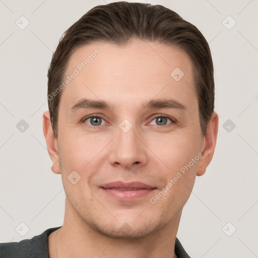 Joyful white young-adult male with short  brown hair and grey eyes