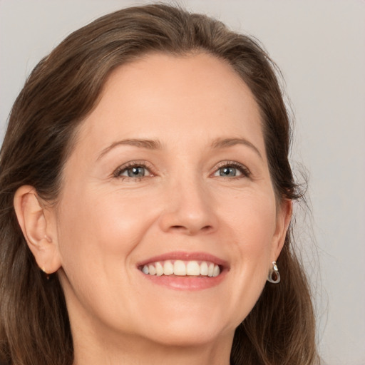 Joyful white adult female with medium  brown hair and brown eyes