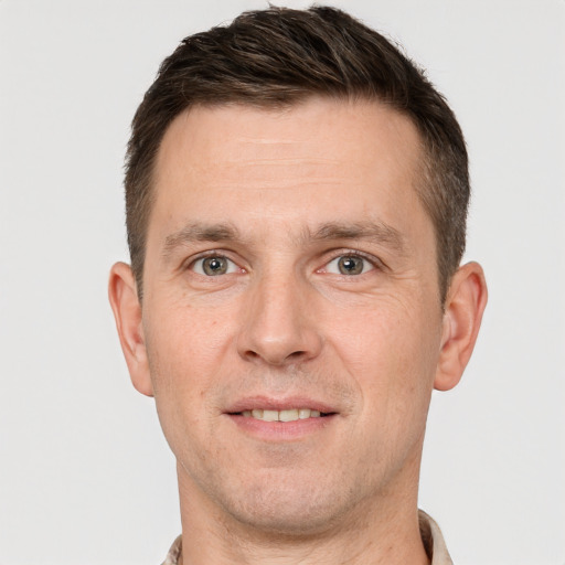 Joyful white adult male with short  brown hair and grey eyes