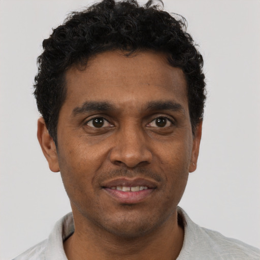 Joyful black young-adult male with short  brown hair and brown eyes
