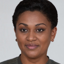 Joyful black young-adult female with short  black hair and brown eyes