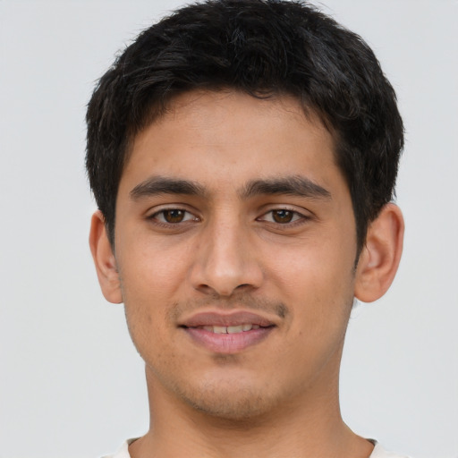 Joyful latino young-adult male with short  brown hair and brown eyes