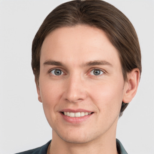 Joyful white young-adult male with short  brown hair and grey eyes