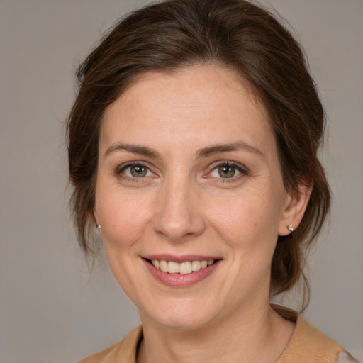 Joyful white adult female with medium  brown hair and grey eyes