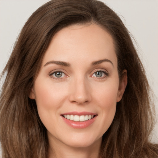 Joyful white young-adult female with long  brown hair and grey eyes