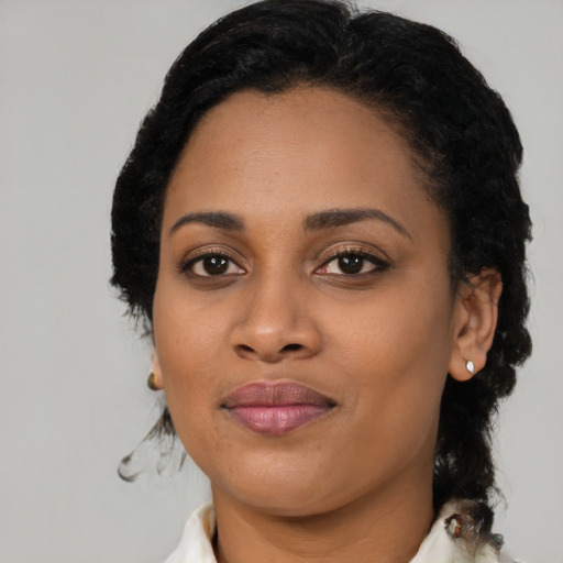 Joyful black young-adult female with short  black hair and brown eyes
