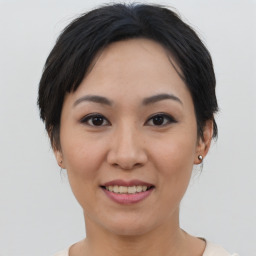 Joyful asian young-adult female with short  brown hair and brown eyes