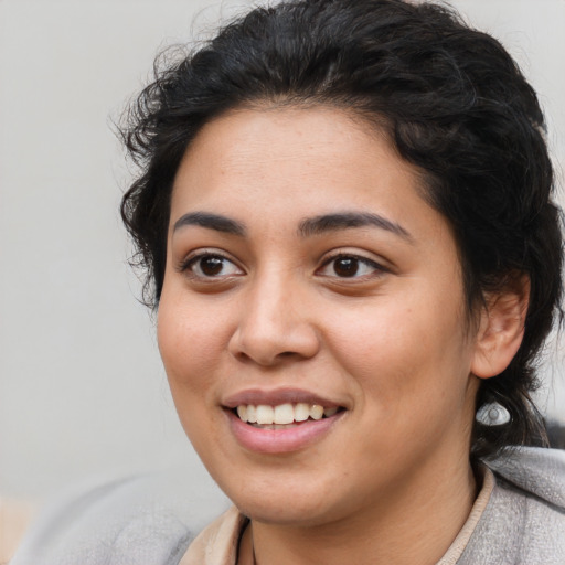 Joyful latino young-adult female with medium  brown hair and brown eyes