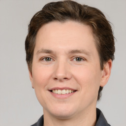 Joyful white adult male with short  brown hair and grey eyes