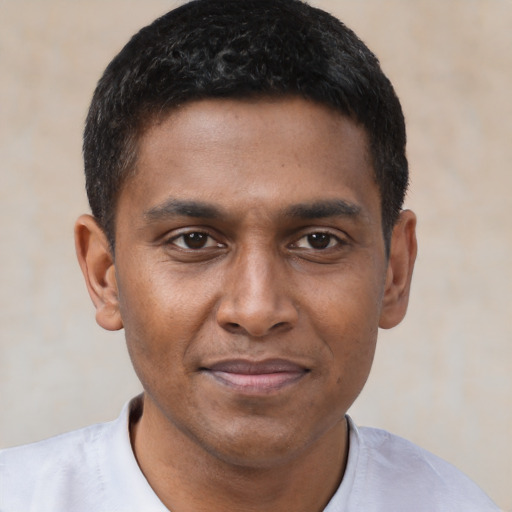 Joyful black young-adult male with short  brown hair and brown eyes