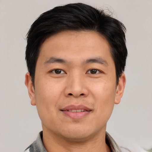 Joyful asian young-adult male with short  brown hair and brown eyes