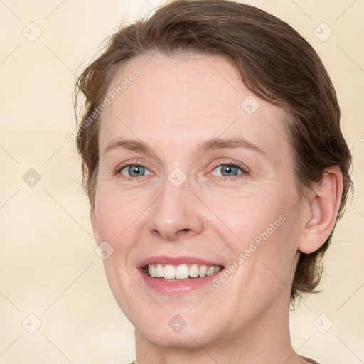 Joyful white adult female with medium  brown hair and green eyes