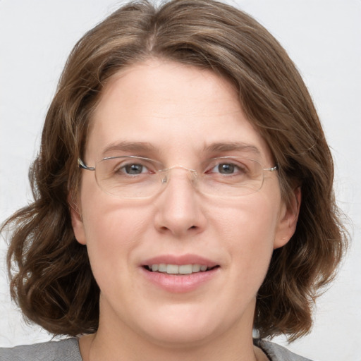 Joyful white adult female with medium  brown hair and grey eyes