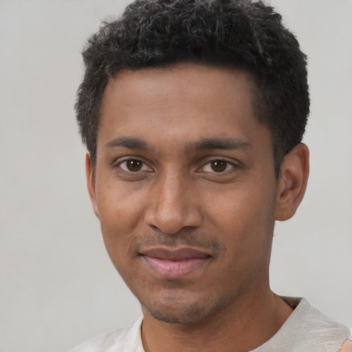 Joyful black young-adult male with short  black hair and brown eyes