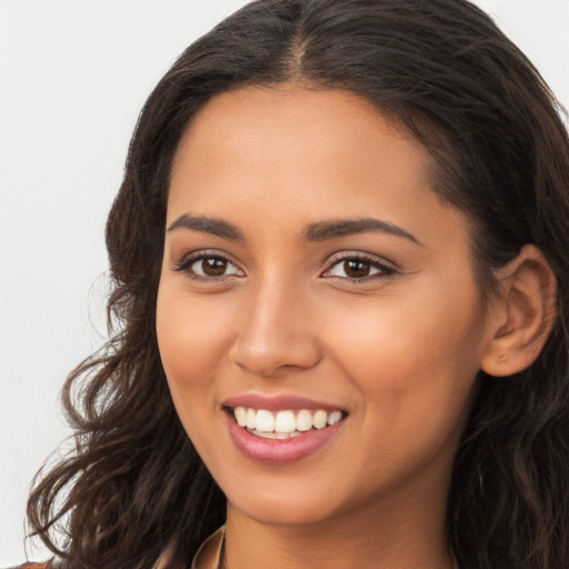 Joyful latino young-adult female with long  brown hair and brown eyes