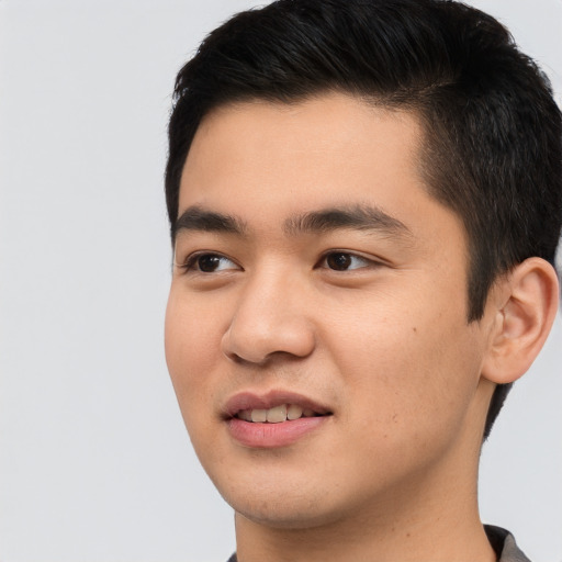 Joyful asian young-adult male with short  black hair and brown eyes