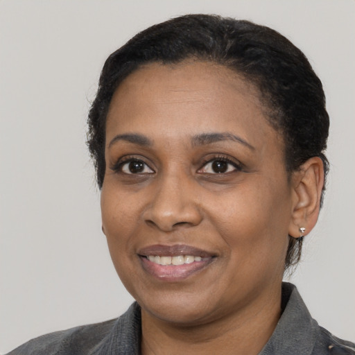 Joyful black adult female with short  black hair and brown eyes