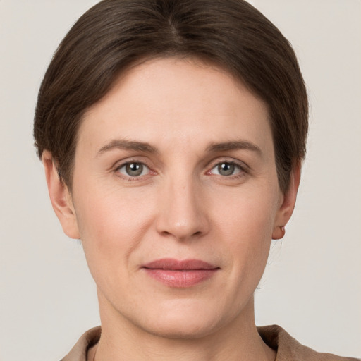 Joyful white young-adult female with short  brown hair and grey eyes