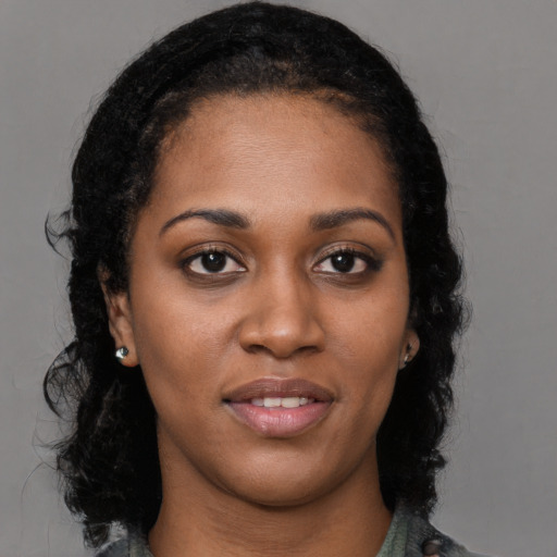 Joyful black young-adult female with long  black hair and brown eyes