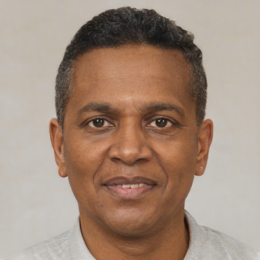 Joyful black adult male with short  black hair and brown eyes