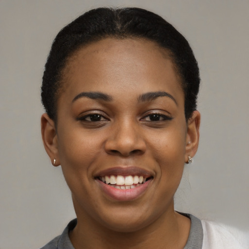 Joyful black young-adult female with short  black hair and brown eyes