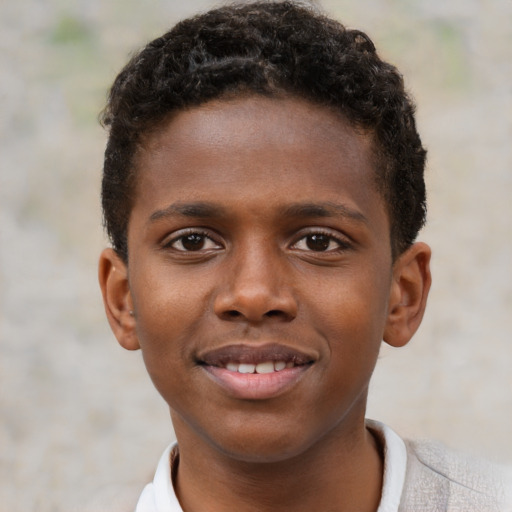 Joyful black child male with short  brown hair and brown eyes