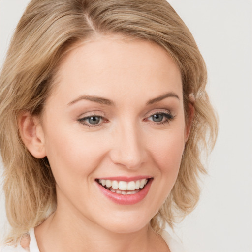 Joyful white young-adult female with medium  brown hair and blue eyes