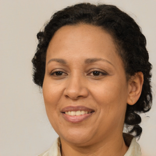 Joyful latino adult female with medium  brown hair and brown eyes