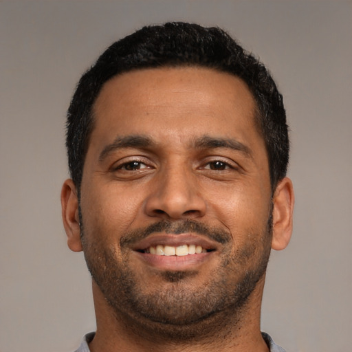 Joyful black young-adult male with short  black hair and brown eyes